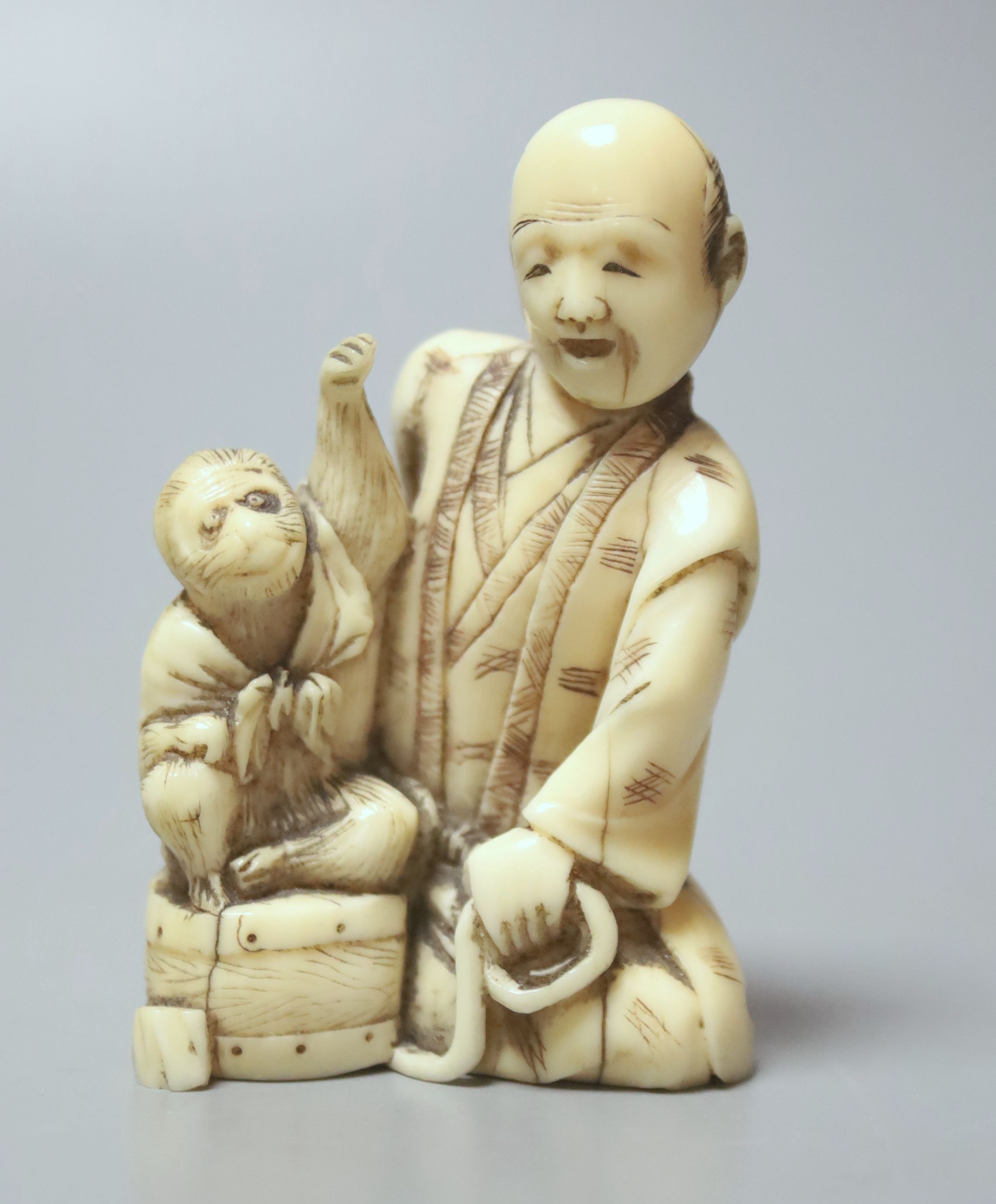 A Japanese ivory group of a man with a monkey, 19th century, 6.5cm high